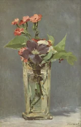 Œillets et clématites dans un vase en cristal